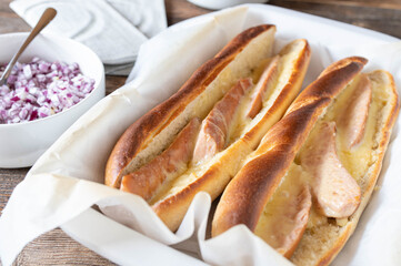 Sausage sandwich with german oven baked, boiled sausages, melted cheese on french baguette