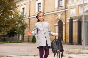 Preteen girl child with backpack outdoors. Pretty schoolgirl going home after class