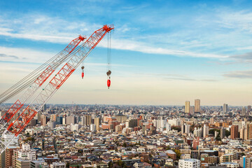 Fototapeta na wymiar Construction industry and development. Crane at work among in Tokyo endless suburbs
