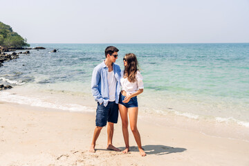 Vacation romantic love young happy smile couple in honeymoon travel holiday trip standing on sand at blue sky sea beach having fun and relaxing together on tropical beach.Summer travel