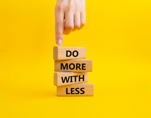 Do more with less symbol. Concept words Do more with less on wooden blocks. Beautiful yellow...