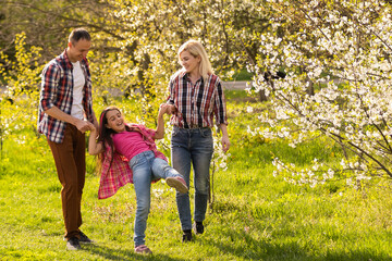 Fototapeta premium Young family with child having fun in nature