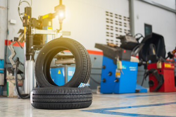 Car tires lying near modern tire changer in auto service center