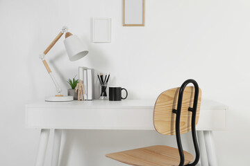 Comfortable workplace with white desk near wall at home