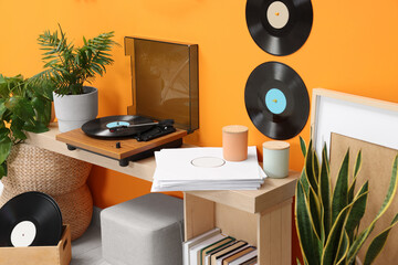 Stylish turntable with vinyl record on console table in cozy room