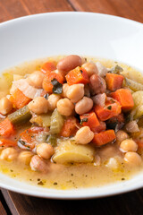 Minestra di verdure e legumi - zuppa di zucchine, patate, carote, bietole, sedano, fagiolini, ceci e fagioli - cibo vegetariano 