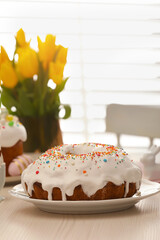 Delicious Easter cake decorated with sprinkles on white wooden table