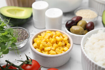 Ingredients for poke bowl on white marble table, closeup
