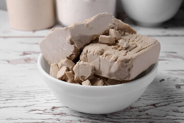 Compressed yeast on white wooden table, closeup