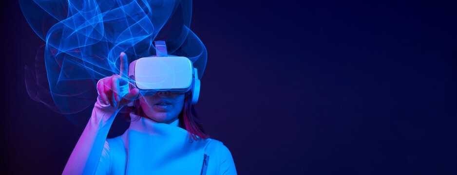 Woman is using virtual reality headset to access in metaverse.