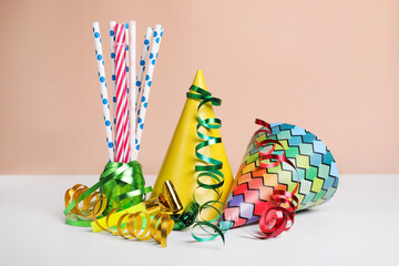 Colorful party hats, streamers and straws on white table. Birthday celebration