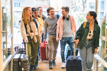 Group of university college tourist walking inside the hotel with suitcases -Young happy students enjoying summer holiday-Tourism Vacation and Lifestyle concept with people-Youth culture-Spring time  - obrazy, fototapety, plakaty