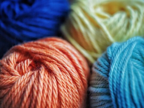 Close Up de cuatro ovillos de hilos de colores para tejer