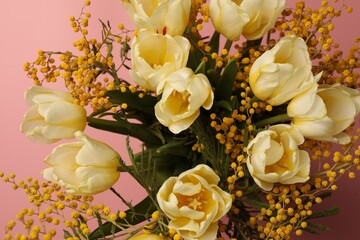 Bouquet with beautiful tulips and mimosa flowers on pink background, closeup