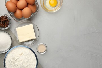 Flat lay composition with flour, butter and different ingredients on light grey table, space for...