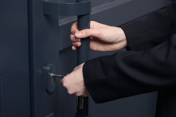 Woman unlocking door with key, closeup view