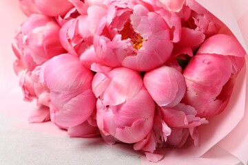 Bouquet of beautiful pink peonies on white table, closeup