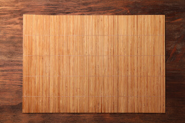 Bamboo mat on wooden table, top view. Space for text