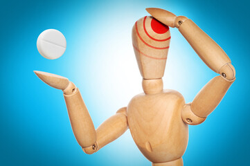 wooden mannequin holding a pill