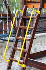 Wooden stairs in playground wet in rain