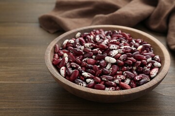 Bowl with dry kidney beans on wooden table