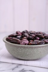Bowl with dry kidney beans on white marble table