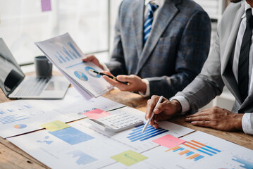 Business People Talking Discussing with financial document data charts and graphs Team business meeting with smart phone and laptop and digital tablet computer