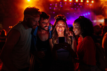 Friends using mobile phone at concert