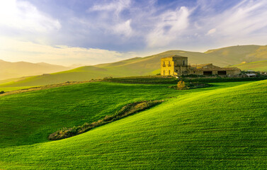 scenery rural view of a contryside farm in green fields and hills with amazing cloudy sky on background