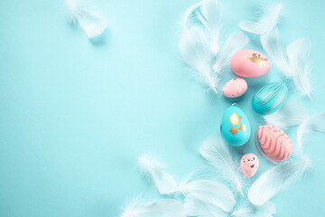 easter decorations feathers sequins pink and white easter eggs on pastel blue background. Easter background
