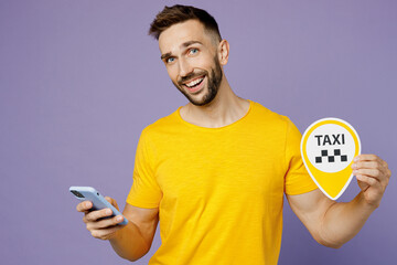Young smiling happy fun caucasian man wear yellow t-shirt use mobile cell phone order taxi hold...