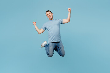 Full body young overjoyed cheerful fun cool smiling happy man wears casual t-shirt jump high do...