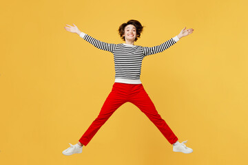 Fototapeta na wymiar Full body excited happy fun cheerful young woman wearing casual black and white shirt jumping high with outstretched hands isolated on plain yellow color background studio portrait. Lifestyle concept.