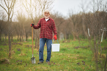 Peasant working in orchard in spring.