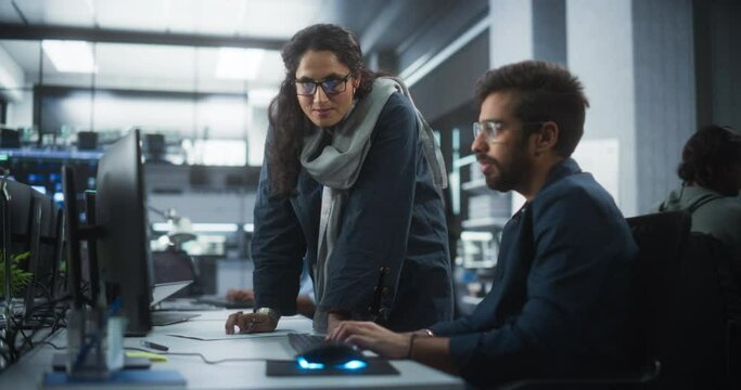 Two Diverse Multiethnic Indian Colleagues Having a Conversation While Busy Working on a Software Development Project. Engneer Talking with a Female Project Manager. Teamwork in Technology Laboratory