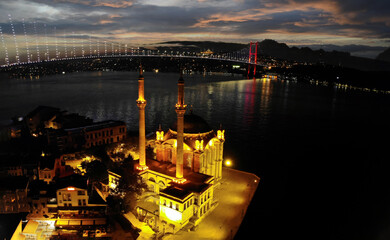 Aerial view of Ortakoy mosque, also known as Buyuk Mecidiye, backgrounded by 15 July Martyrs bridge and Bosphorus strait in Besiktas district, Istanbul, Turkey.