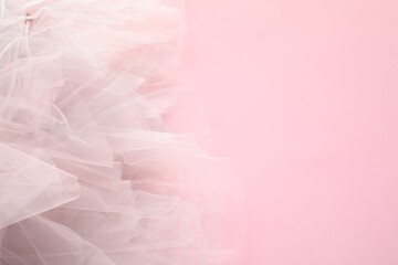 Beautiful tulle fabric on pink background, top view. Space for text