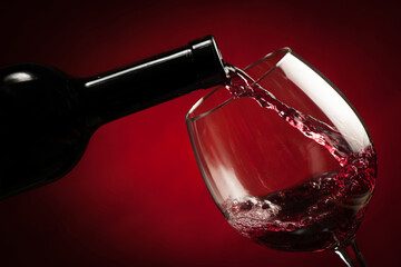 Bottle filling the glass of wine - splash of delicious flavor.