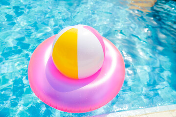 inflatable pool with swimming ring and rings in a water on blue background in the summer day.