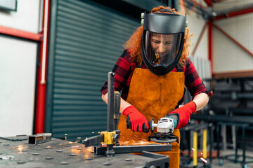 A self-taught girl grinds in the workshop, uses a visor and gloves for protection