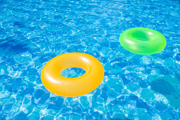 inflatable pool with swimming ring and rings in a water on blue background in the summer day.