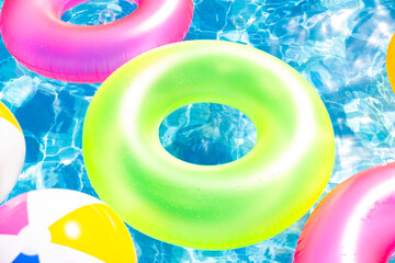 inflatable pool with swimming ring and rings in a water on blue background in the summer day.