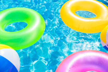 inflatable pool with swimming ring and rings in a water on blue background in the summer day.