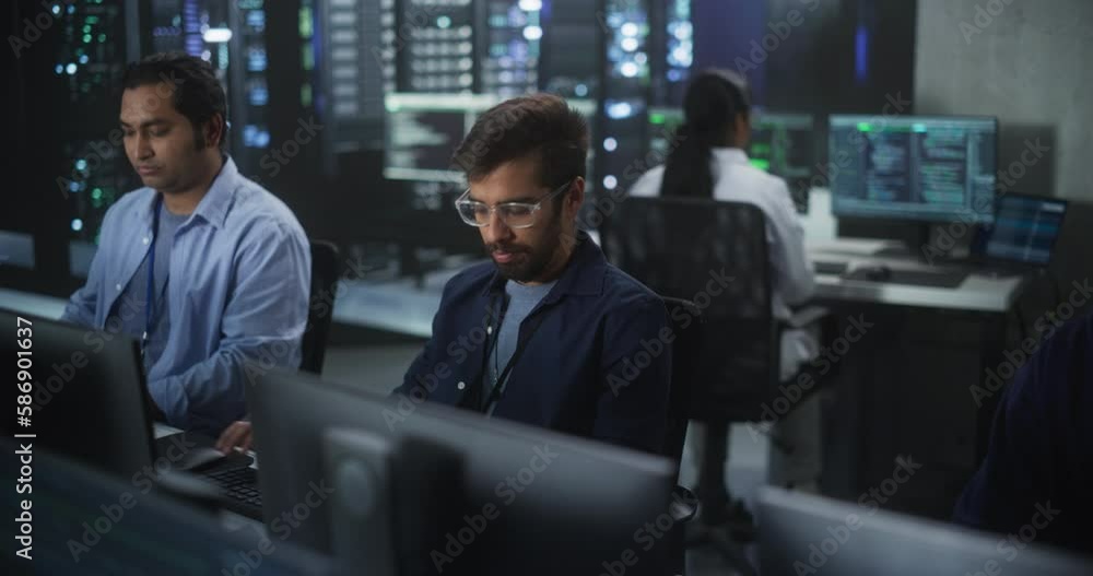 Poster Portrait of a Handsome Indian Engineer Working on Desktop Computer in a Technological Office Environment. Research and Development Department Writing Software Code for an Innovative Internet Project