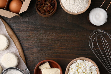 Flat lay composition with uncooked cottage cheese pancakes and different ingredients on wooden table, space for text