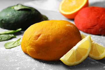 Dough painted with natural food coloring and lemon on light grey table, closeup