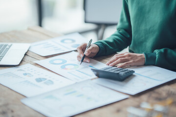 Financial Businesswomen analyze the graph of the company's performance to create profits and growth, Market research reports and income statistics, Financial and Accounting concept.