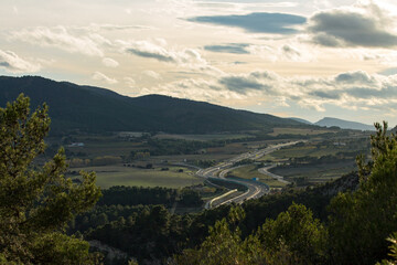 Autovia Alcoy Ibi vista desde el Puig de Alcoy a contraluz con cielo nublado