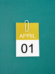 The April 1st calendar sheet with paper clip on dark green background.