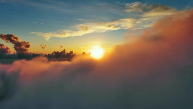 Flying above the clouds. Aerial view of clouds and sunset sun. Traveling by air perfect background, 4k